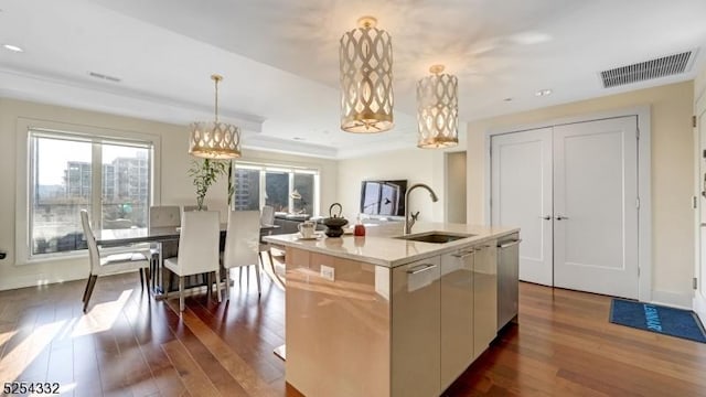 kitchen featuring dark wood-type flooring, sink, decorative light fixtures, a center island with sink, and dishwasher