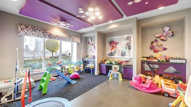 game room featuring a raised ceiling