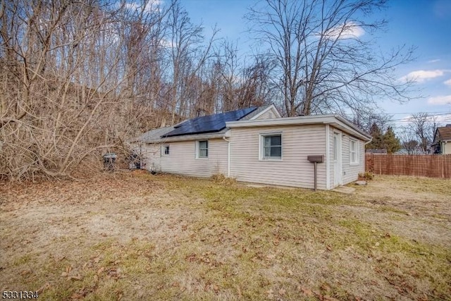 view of side of property featuring a yard and solar panels