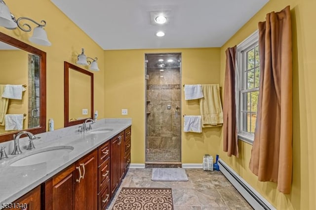 bathroom with vanity, a shower with shower door, and a baseboard heating unit