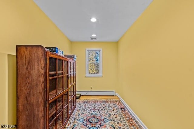 interior space with light wood-type flooring and baseboard heating