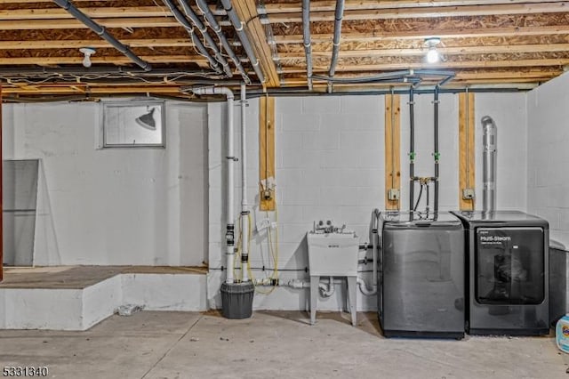 basement featuring independent washer and dryer and sink