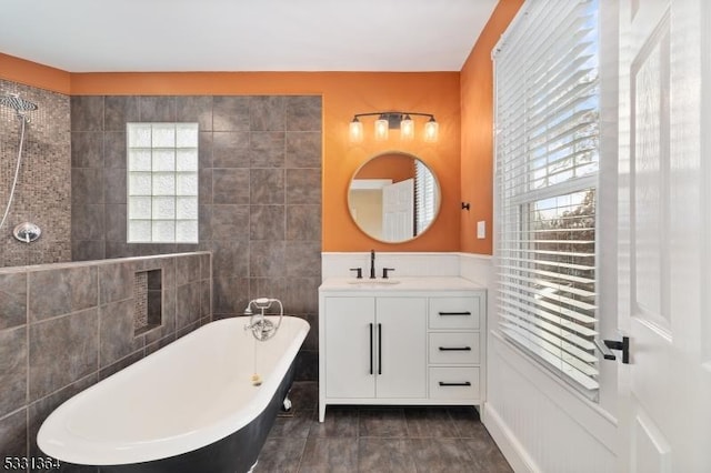 bathroom featuring a bathing tub, vanity, tile patterned floors, and tile walls