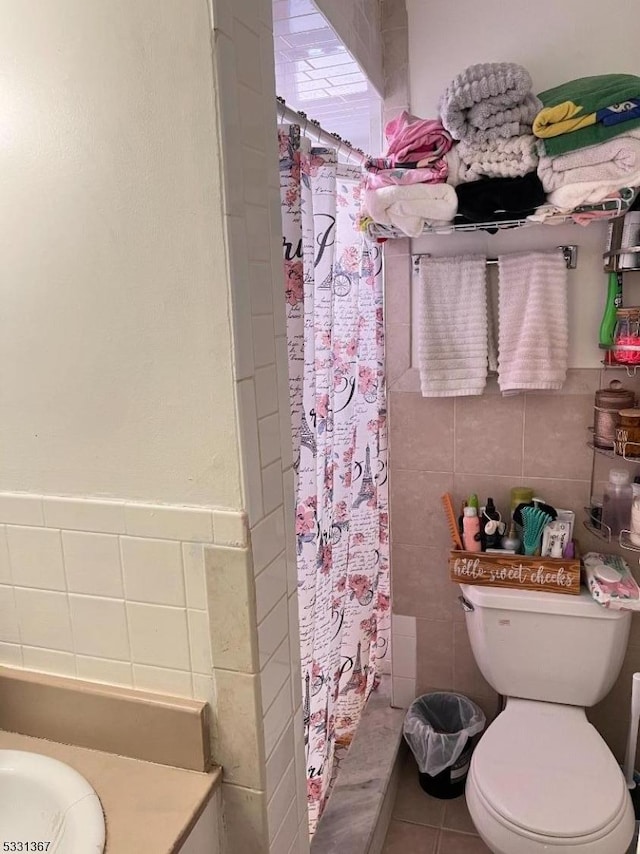 bathroom featuring a shower with curtain, tile patterned flooring, tile walls, and toilet