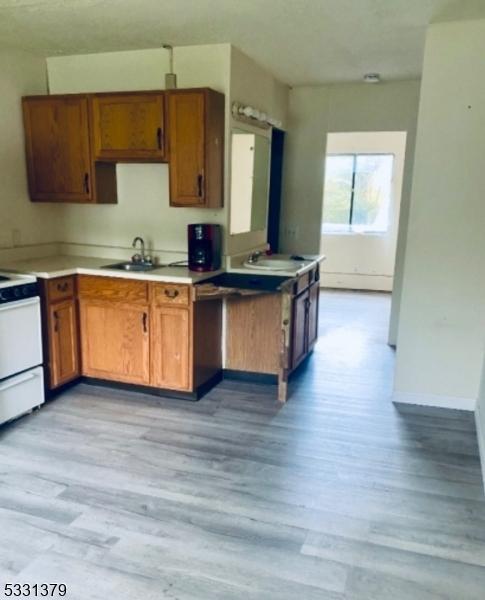 kitchen with sink, white electric range oven, and light hardwood / wood-style floors