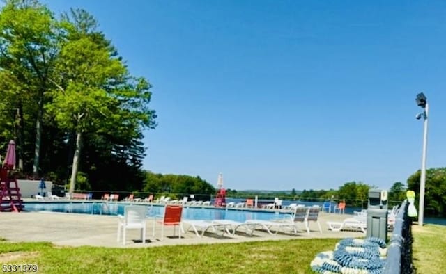 view of pool with a patio area and a lawn