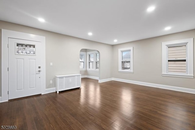 foyer with radiator and dark wood-type flooring