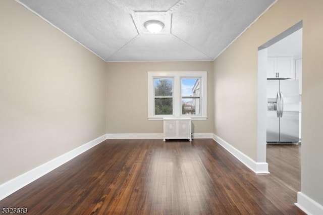 empty room featuring dark hardwood / wood-style flooring and a textured ceiling