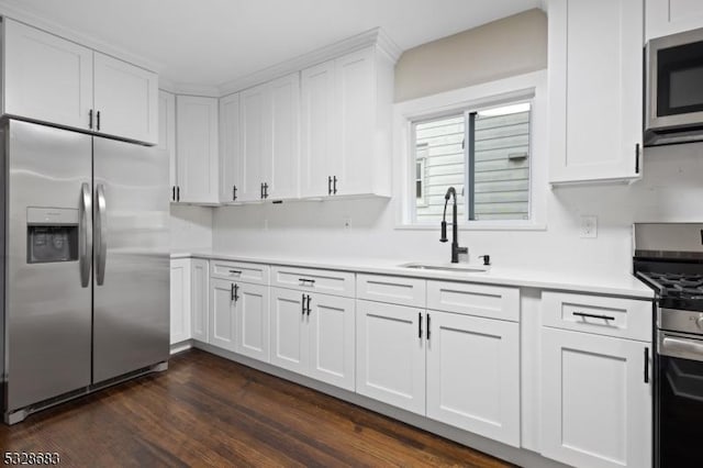 kitchen featuring stainless steel appliances, white cabinetry, dark hardwood / wood-style floors, and sink