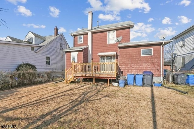 rear view of house featuring a yard and a wooden deck