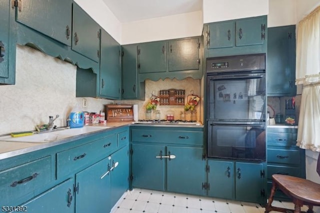 kitchen featuring sink, black double oven, and stainless steel gas cooktop