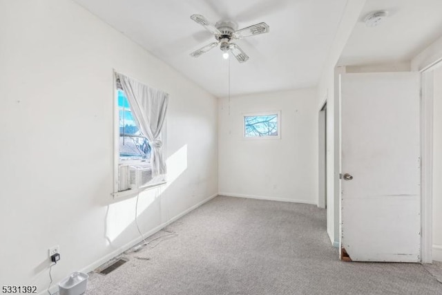 carpeted empty room featuring ceiling fan and plenty of natural light