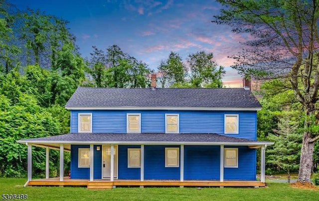 country-style home with a porch and a yard