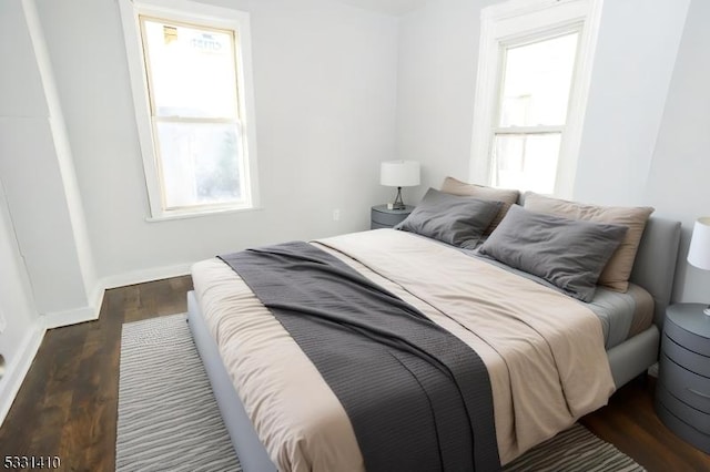 bedroom featuring multiple windows and dark hardwood / wood-style floors