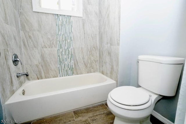 bathroom featuring tiled shower / bath and toilet