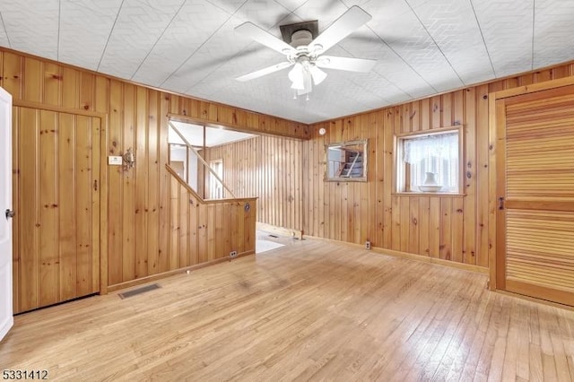 spare room featuring visible vents, baseboards, ceiling fan, and hardwood / wood-style flooring