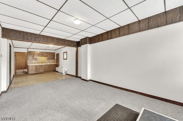 finished basement with light carpet, a drop ceiling, and baseboards