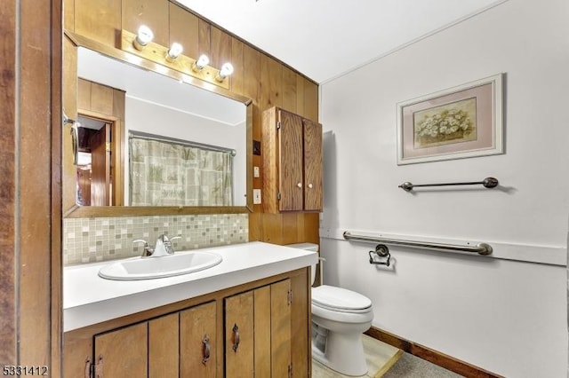 bathroom featuring tasteful backsplash, vanity, and toilet