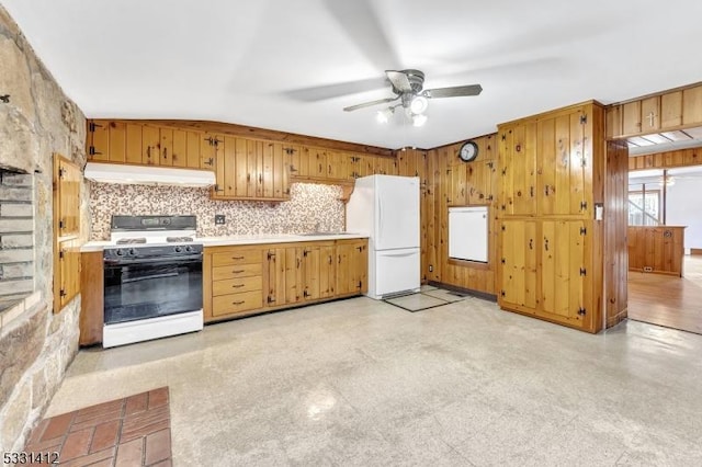 kitchen with under cabinet range hood, gas range oven, freestanding refrigerator, light countertops, and ceiling fan