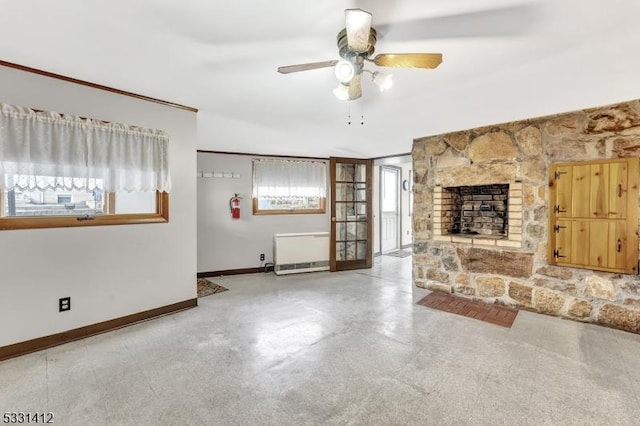 unfurnished living room with baseboards, radiator, and ceiling fan