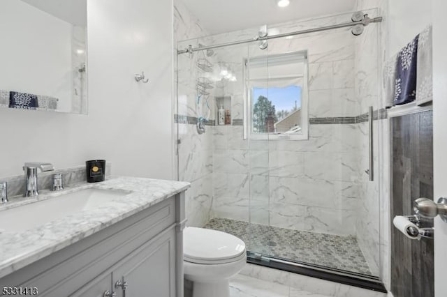 bathroom featuring vanity, toilet, and a shower with shower door