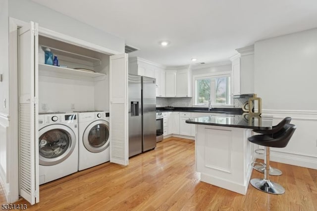 washroom featuring separate washer and dryer, sink, and light hardwood / wood-style floors