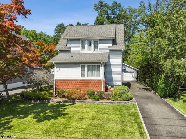 view of front of home with an outbuilding, a front lawn, and a garage