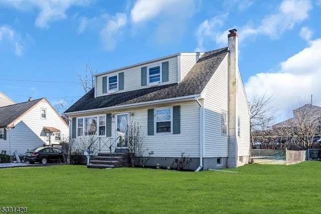 view of front of property with a front yard, roof with shingles, fence, and a chimney