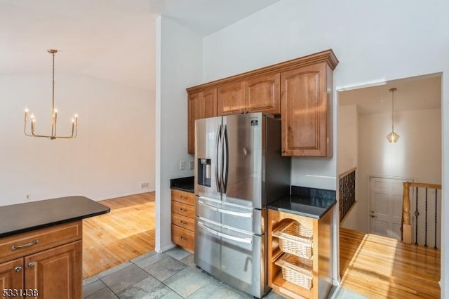 kitchen with pendant lighting, stainless steel refrigerator with ice dispenser, and a notable chandelier