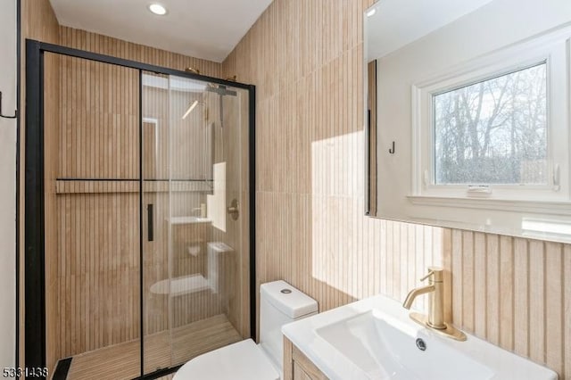 bathroom with vanity, a shower with shower door, and toilet