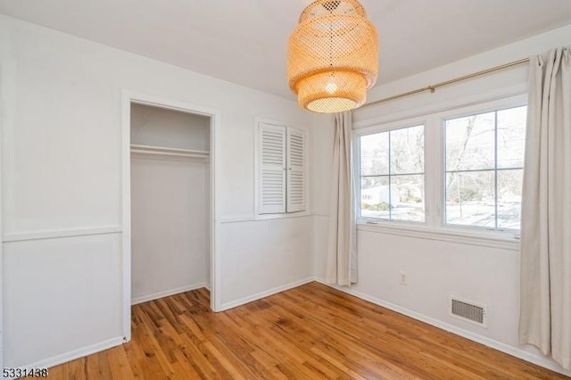 unfurnished bedroom with a closet and light hardwood / wood-style floors