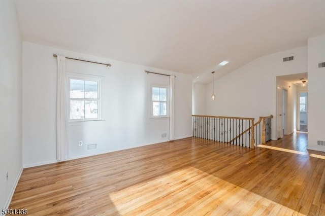 unfurnished room featuring wood-type flooring and vaulted ceiling