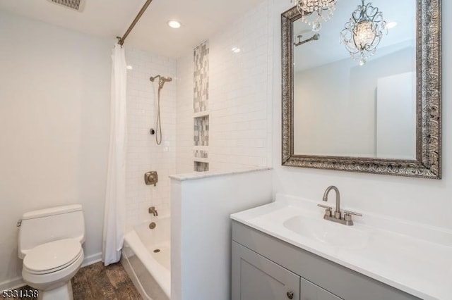 full bathroom with vanity, shower / tub combo with curtain, an inviting chandelier, hardwood / wood-style floors, and toilet