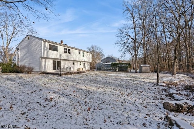 view of snow covered rear of property