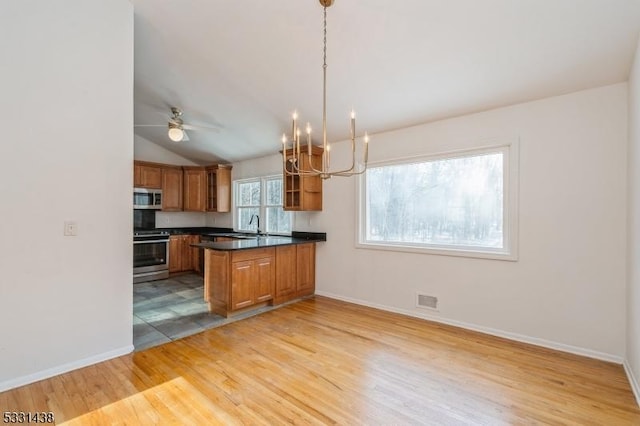 kitchen featuring stainless steel appliances, light hardwood / wood-style flooring, kitchen peninsula, decorative light fixtures, and ceiling fan with notable chandelier