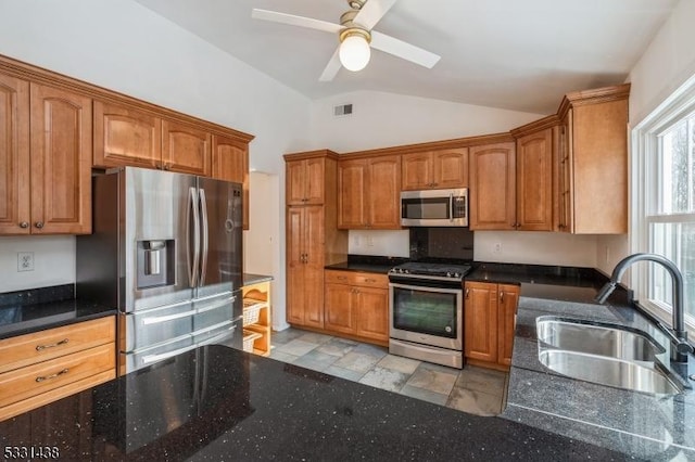 kitchen with ceiling fan, sink, lofted ceiling, and stainless steel appliances