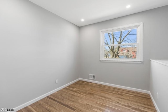 empty room featuring visible vents, baseboards, wood finished floors, and recessed lighting