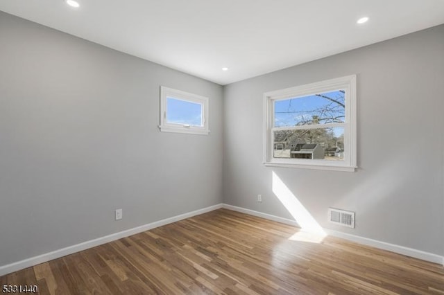 unfurnished room with recessed lighting, visible vents, baseboards, and wood finished floors