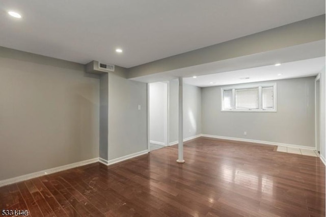 below grade area featuring baseboards, visible vents, wood finished floors, and recessed lighting