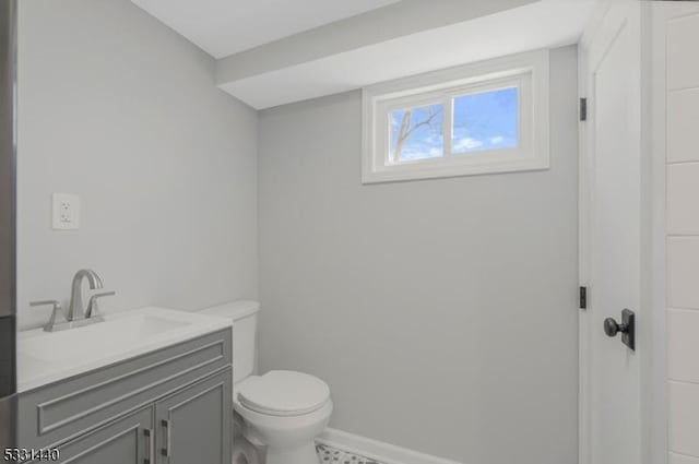 bathroom with vanity, toilet, and baseboards