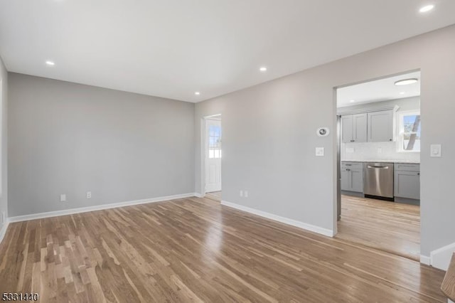 unfurnished living room with light wood-style flooring, baseboards, and recessed lighting