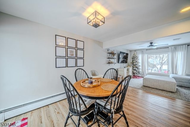 dining area featuring ceiling fan, light wood-type flooring, and a baseboard radiator