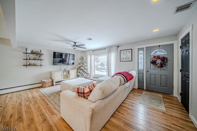 living room featuring ceiling fan, light hardwood / wood-style floors, and baseboard heating