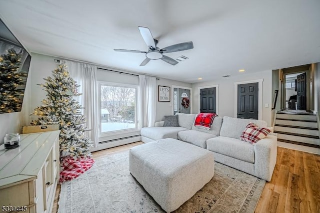 living room with light hardwood / wood-style floors, a baseboard radiator, and ceiling fan