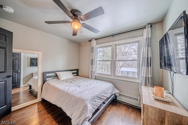 bedroom with dark hardwood / wood-style flooring, a baseboard radiator, and ceiling fan