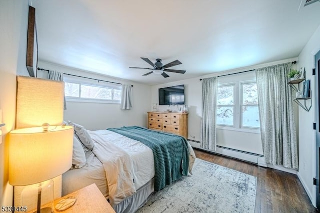 bedroom with hardwood / wood-style floors, ceiling fan, baseboard heating, and multiple windows