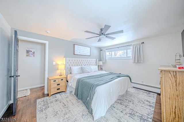 bedroom featuring hardwood / wood-style floors, ceiling fan, and a baseboard heating unit