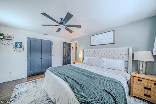 bedroom with a closet, ceiling fan, and dark hardwood / wood-style flooring