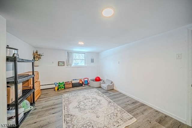 playroom featuring light wood-type flooring and baseboard heating