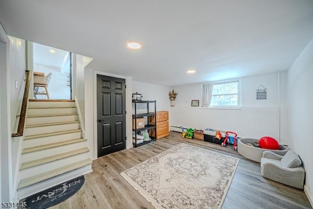 playroom featuring baseboard heating and hardwood / wood-style floors